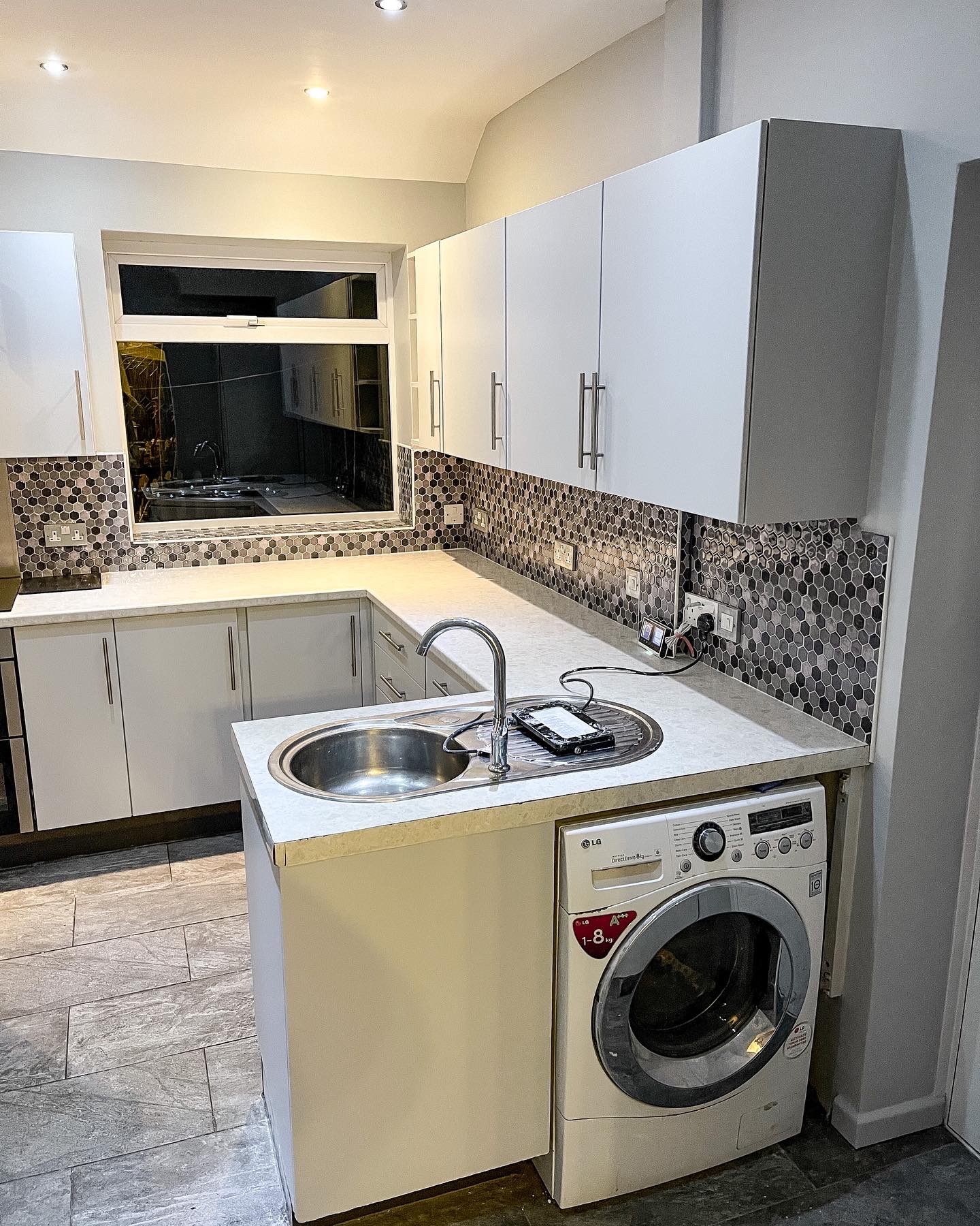 Utility room with clean white walls and cabinets