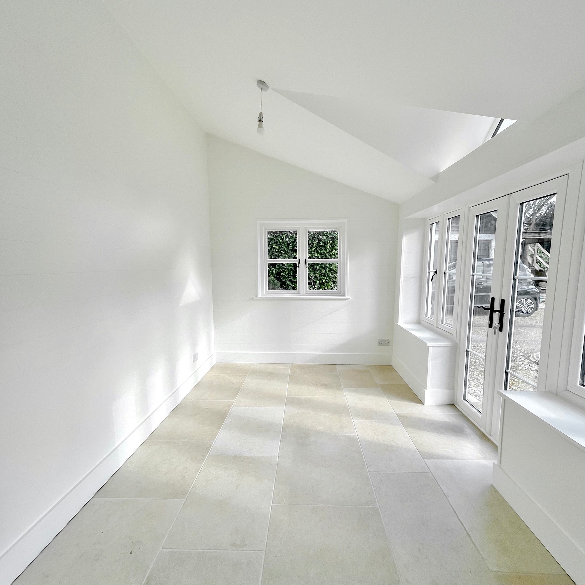 Bright garden room with fresh white walls and French doors